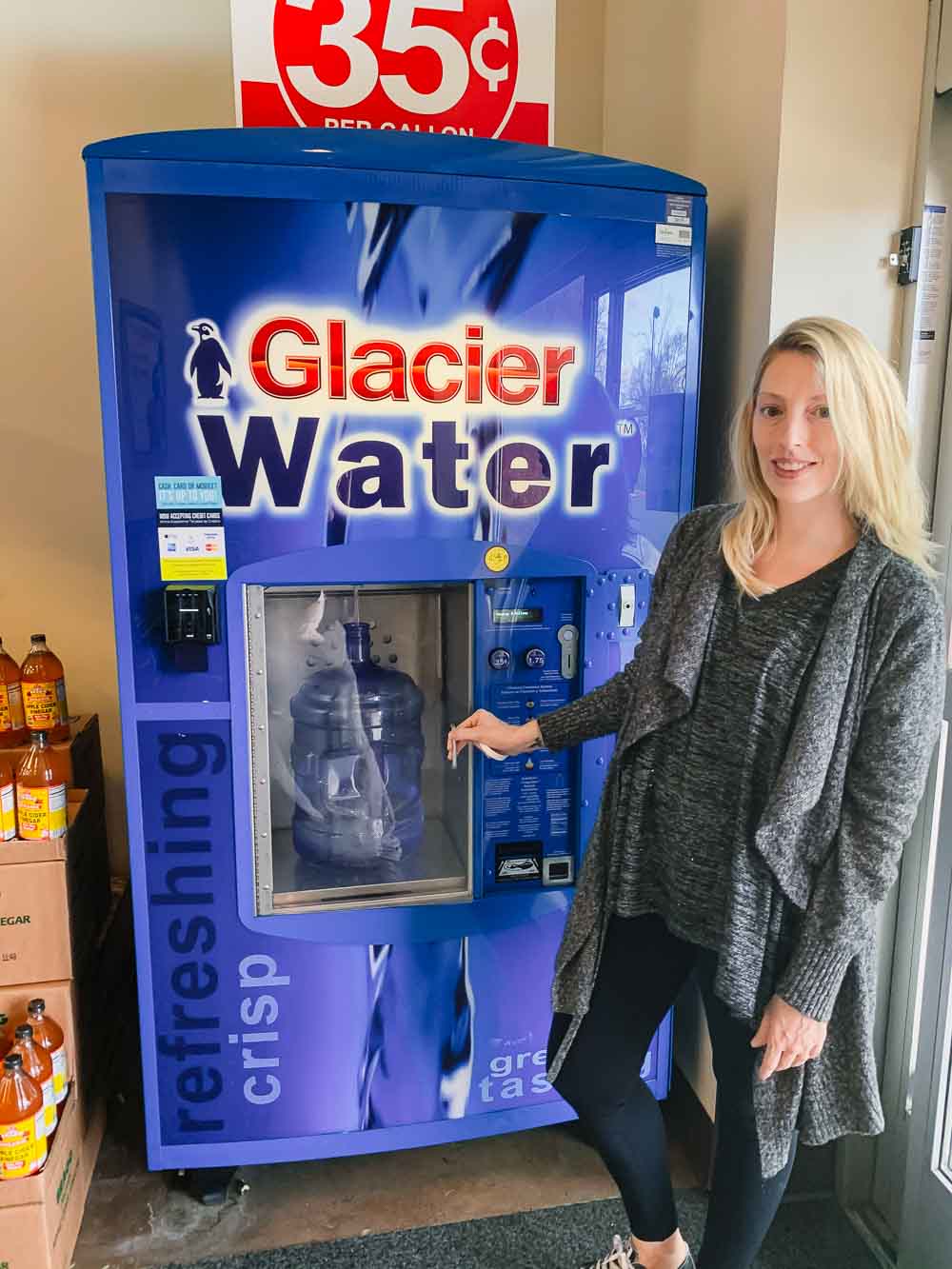 a woman refilling a primo water bottle at a glacier water refill station