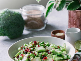 a white salad bowl on a floral napkin on a blue table with the words "leftover broccoli stem salad" in black writing