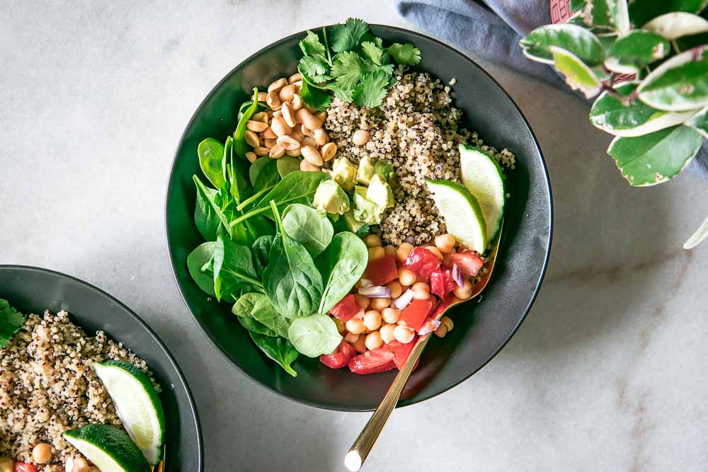 simple quinoa and spinach salad in a black bowl on a white table