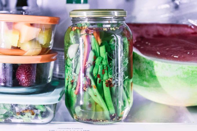 a jar of pickled green beans in a refrigerator