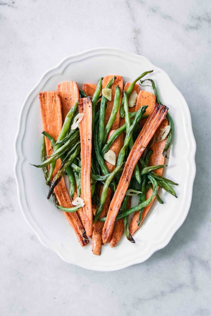 roasted haricots verts and carrots on a white plate