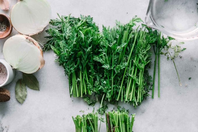 sliced carrot tops on a white cutting board