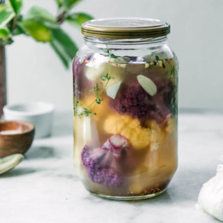 a jar of refrigerator pickled cauliflowers on a white table