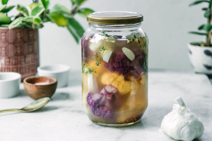a jar of refrigerator pickled cauliflowers on a white table
