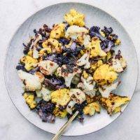 a white plate with baked white, purple, and orange cauliflower
