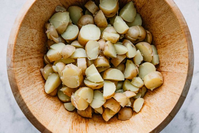 cut white creamer potatoes in a large wooden bowl