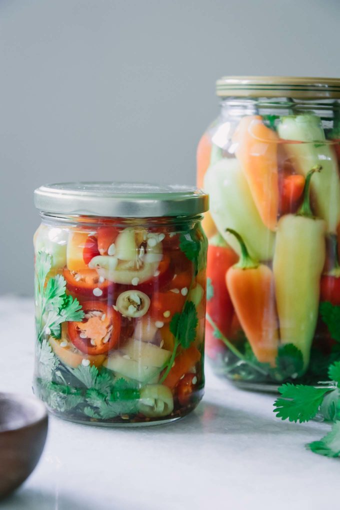 a jar of sliced pickled peppers on a white table