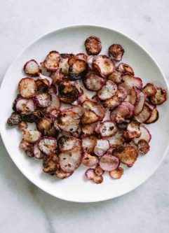 crispy baked radishes on a white plate