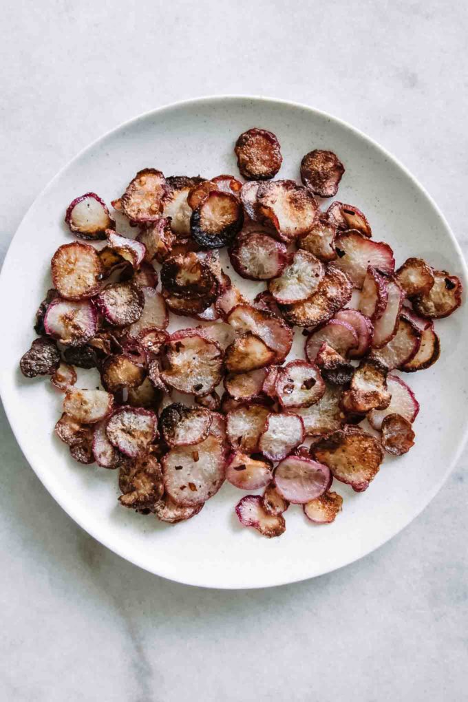 crispy baked radishes on a white plate