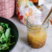 maple vinaigrette in a glass jar with a gold spoon