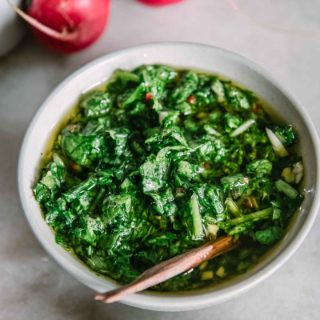 chimichurri made from radish greens in a white bowl on a marble table