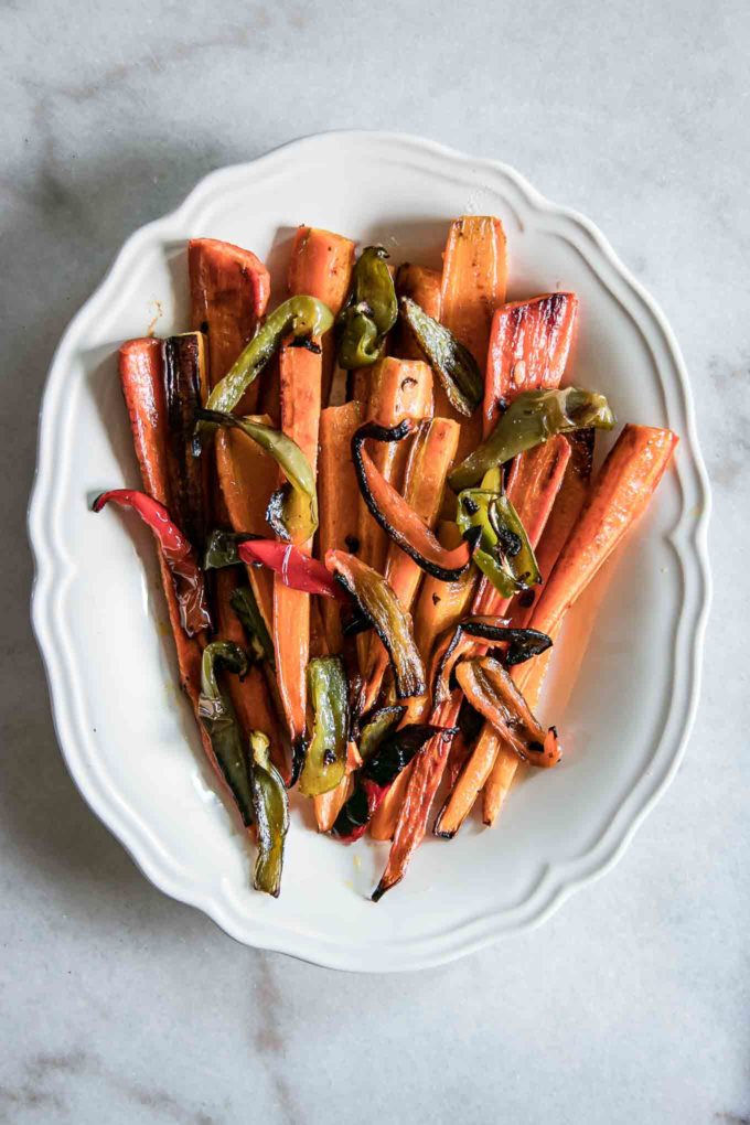 oven roasted long carrots and sliced bell peppers on a serving plate