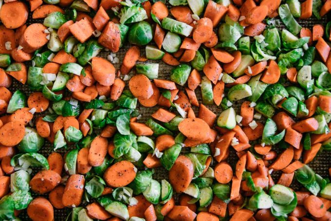 cut carrots and brussels sprouts on a sheet pan