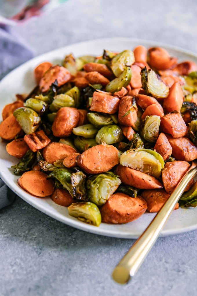 a plate of baked carrots and brussels sprouts