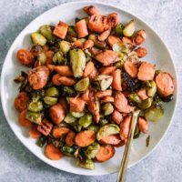 roasted carrots and brussels sprouts on a white p