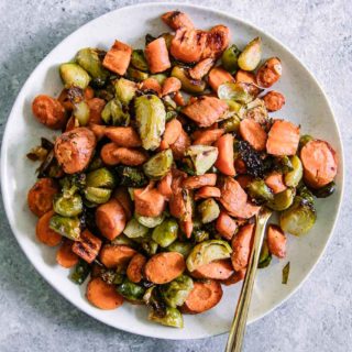 roasted carrots and brussels sprouts on a white p