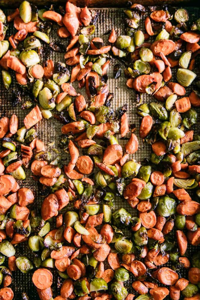 roasted carrots and brussels sprouts on a roasting pan