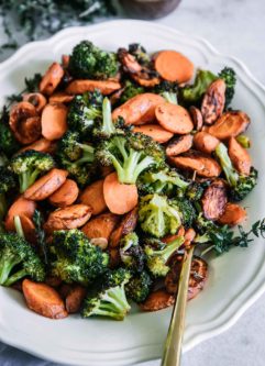 oven roasted carrots and broccoli on a white plate with a gold fork