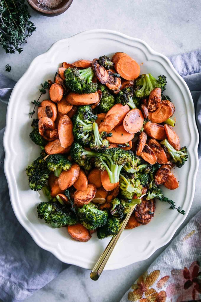 baked broccoli and carrots on a white plate on a white table