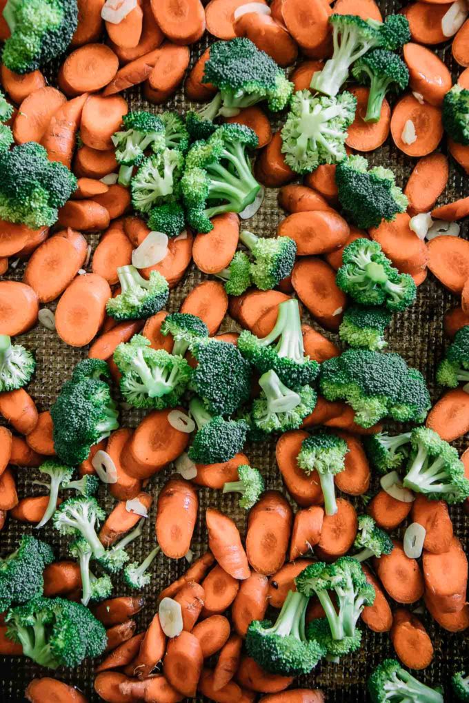 raw cut carrots and broccoli florets on a baking sheet before roasting