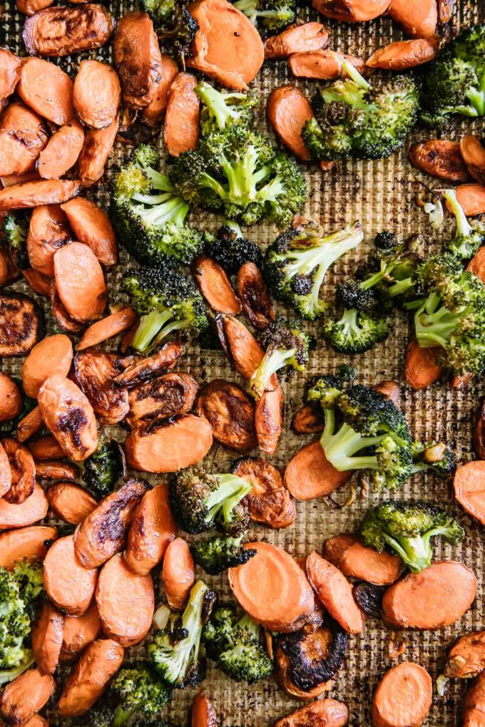 cooked carrots and broccoli on a sheet pan after roasting