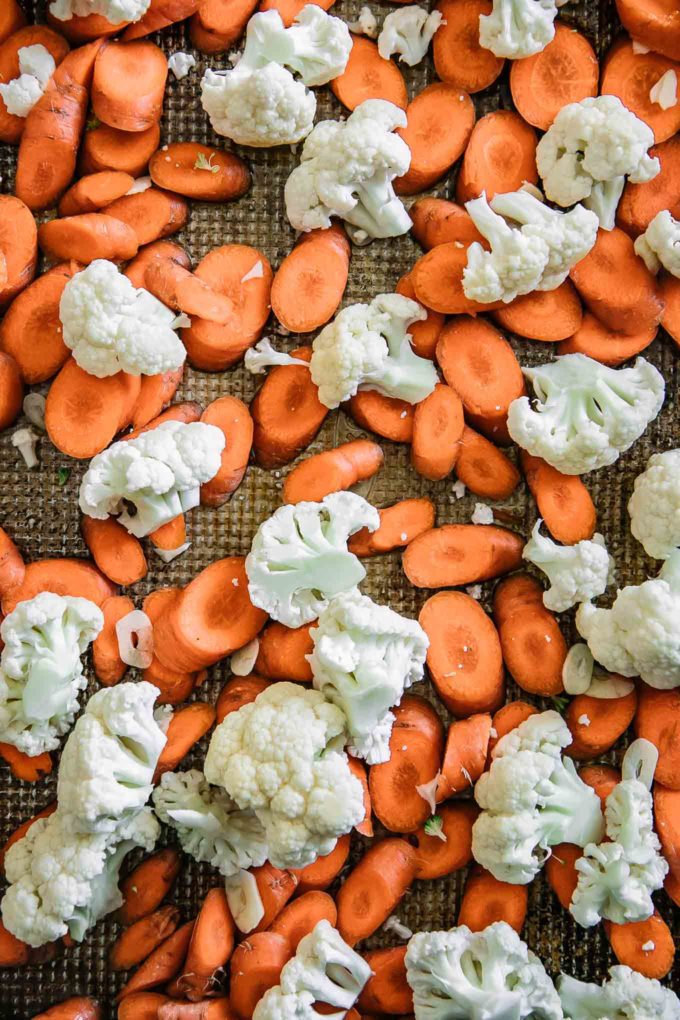 sliced carrots and cauliflower florets on a sheet pan