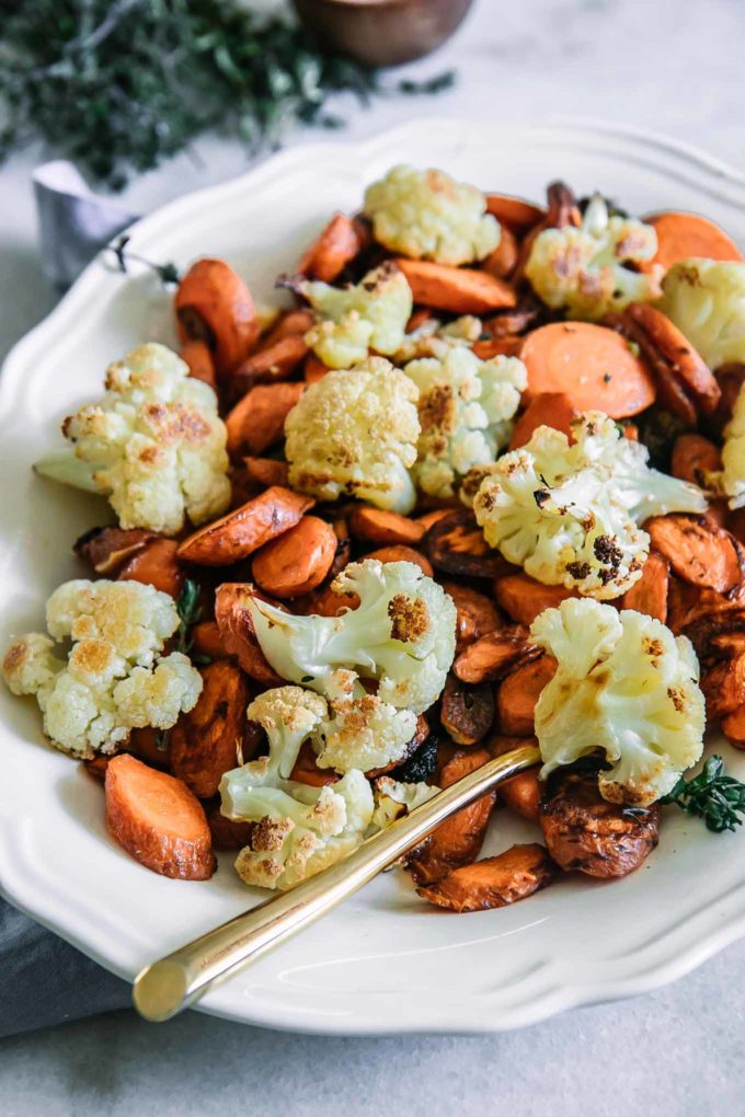bake carrots and cauliflower in a white serving dish on a white table