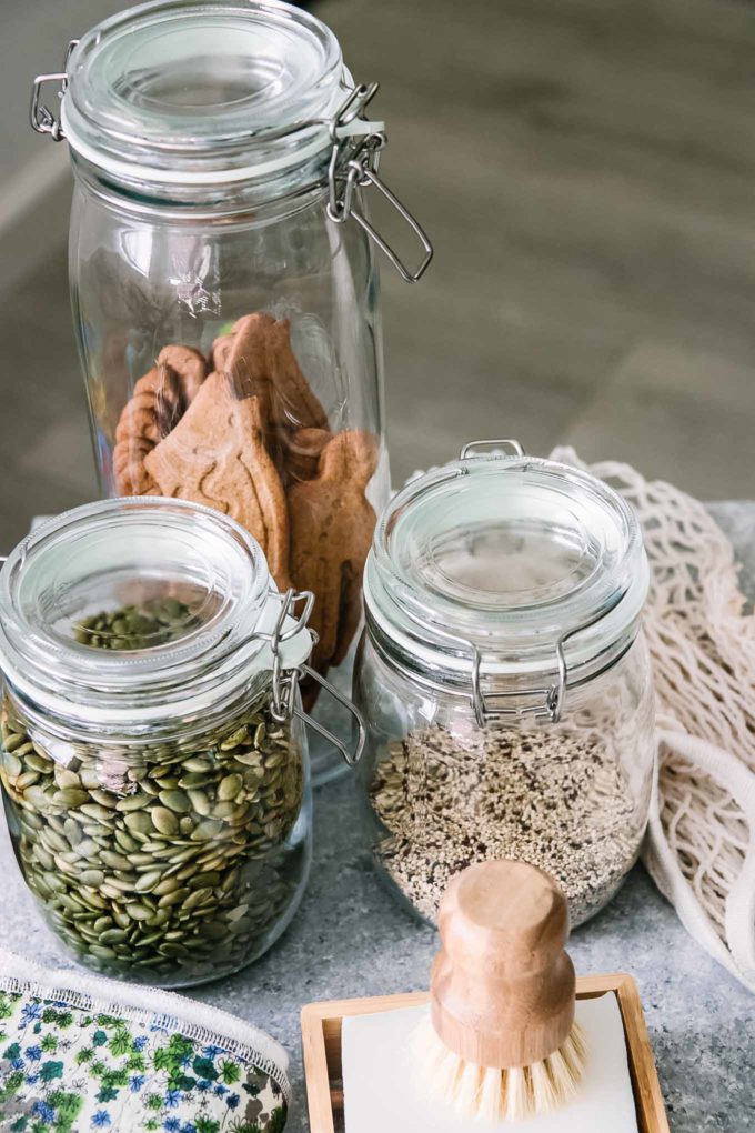 glass food storage containers filled with dried foods on a blue table