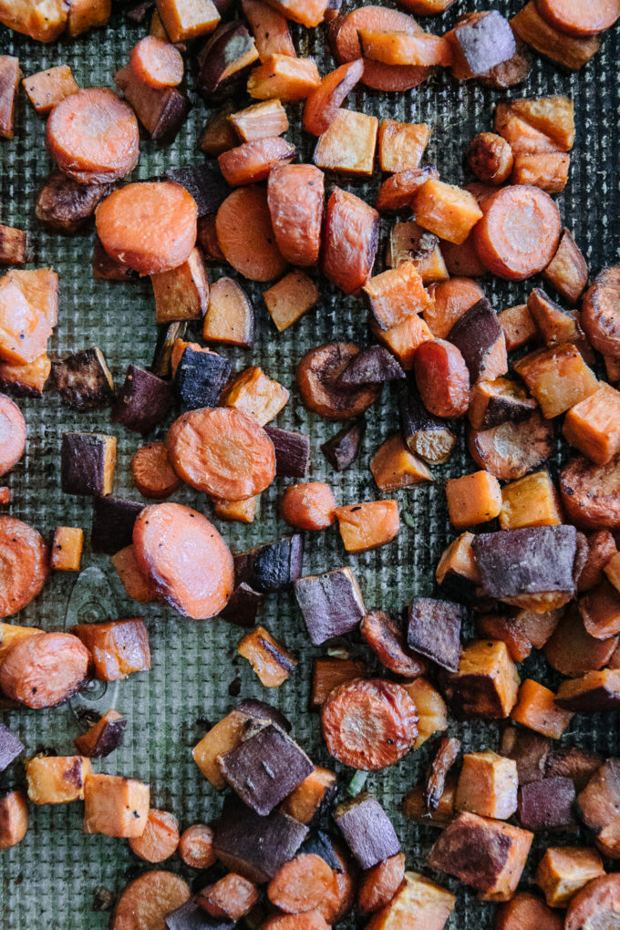 baked sweet potatoes and carrots on a sheet pan after roasting
