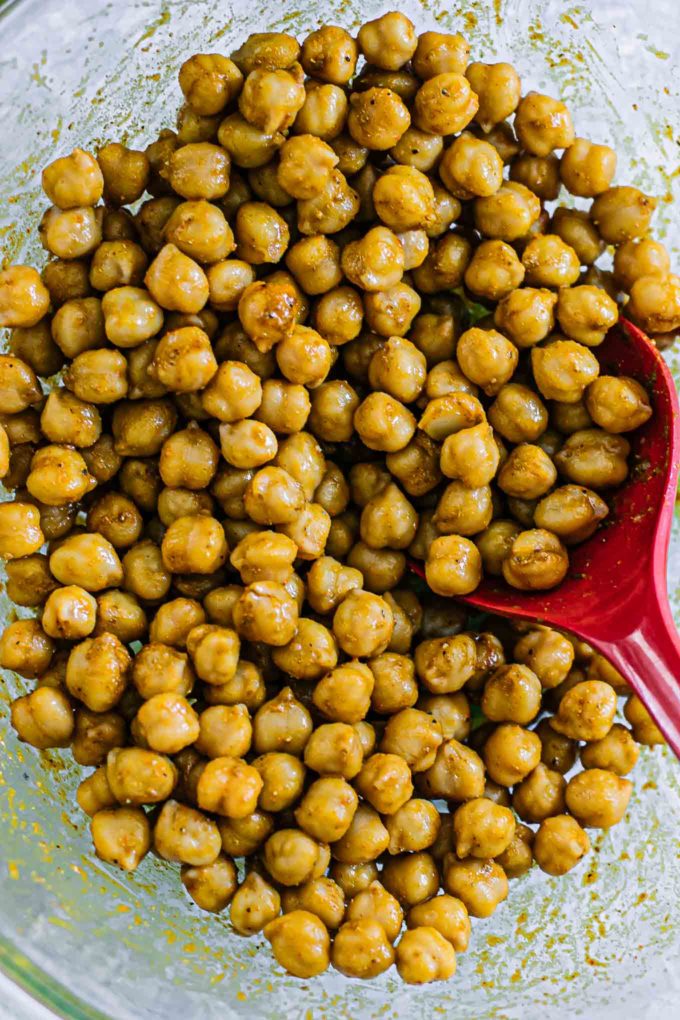 spiced chickpeas in a mixing bowl with a red spoon