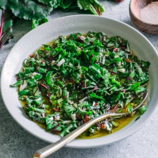 a bowl of chimichurri on a blue table