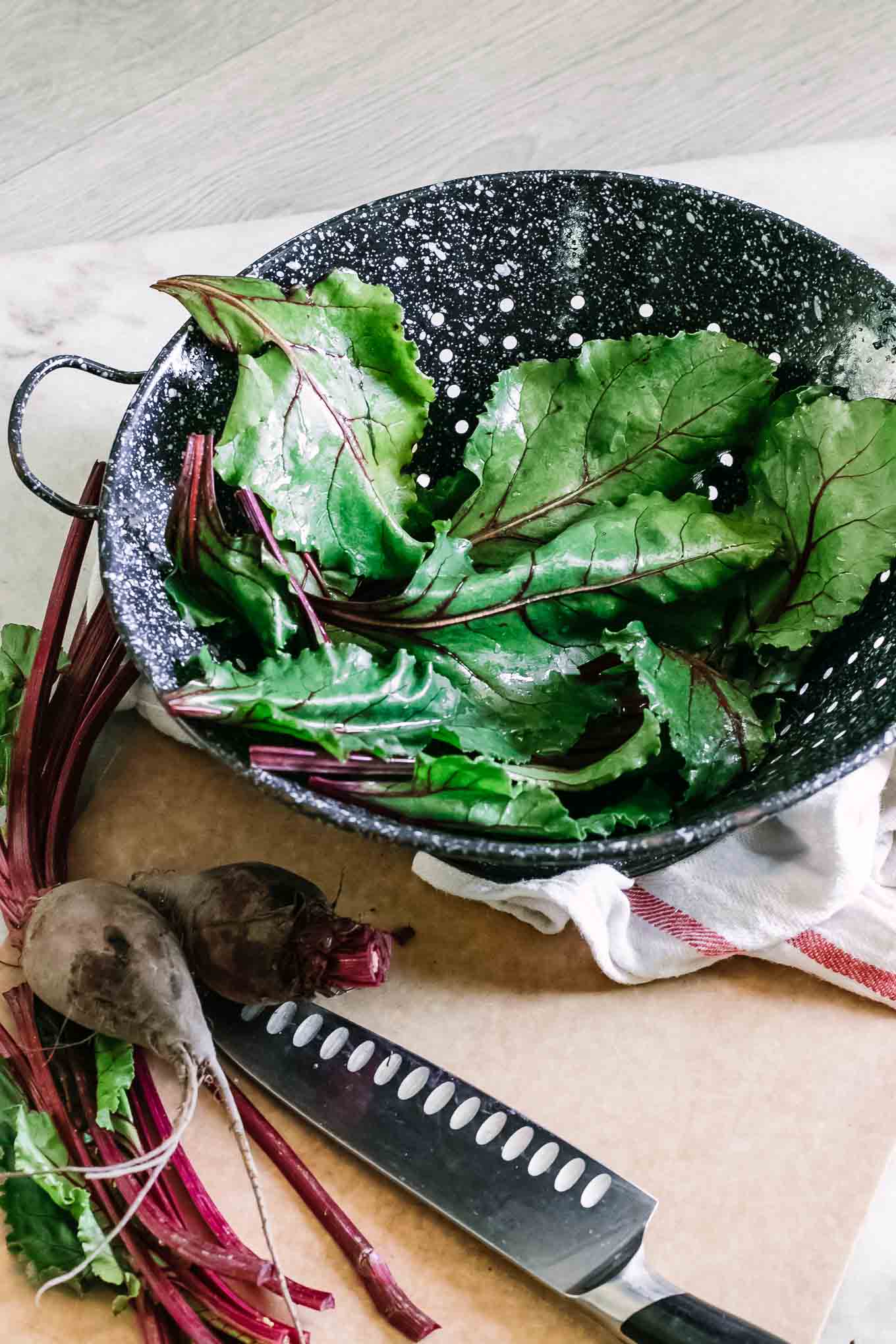 washed beet greens in a blue colander