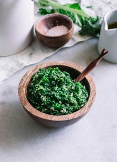 kale pesto in a wooden bowl on a white table