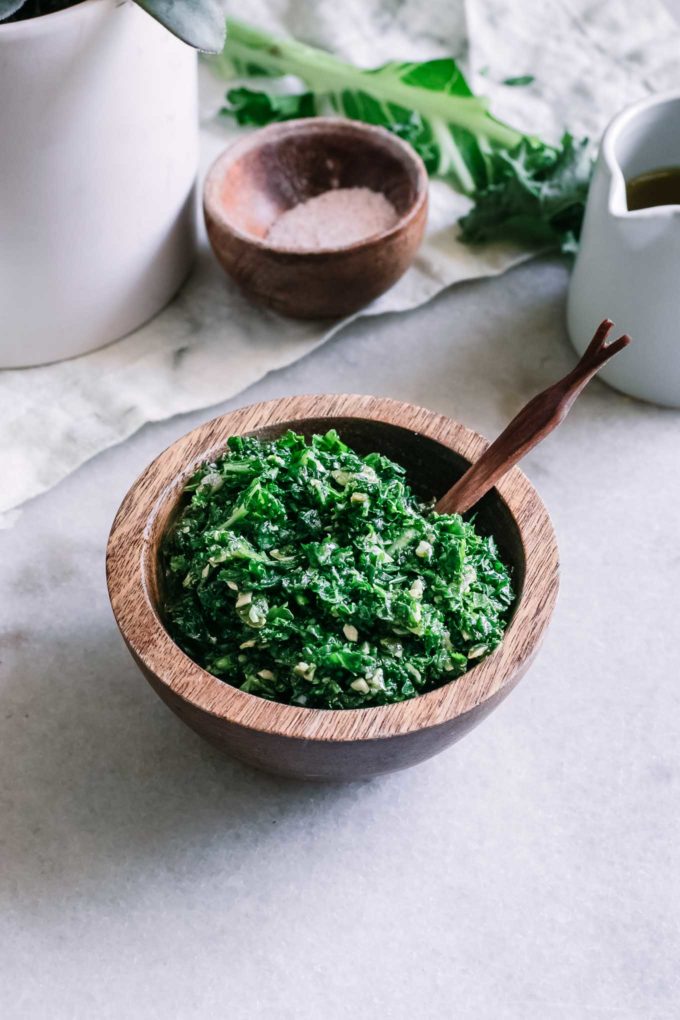 kale pesto in a wooden bowl on a white table