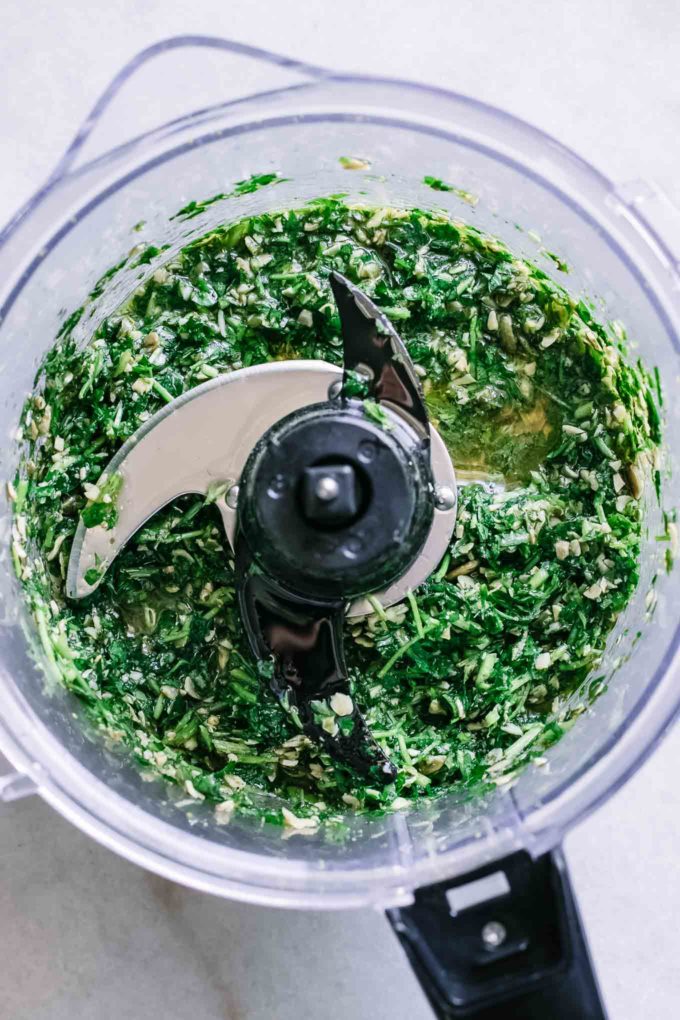 blended parsley pesto inside a food processor