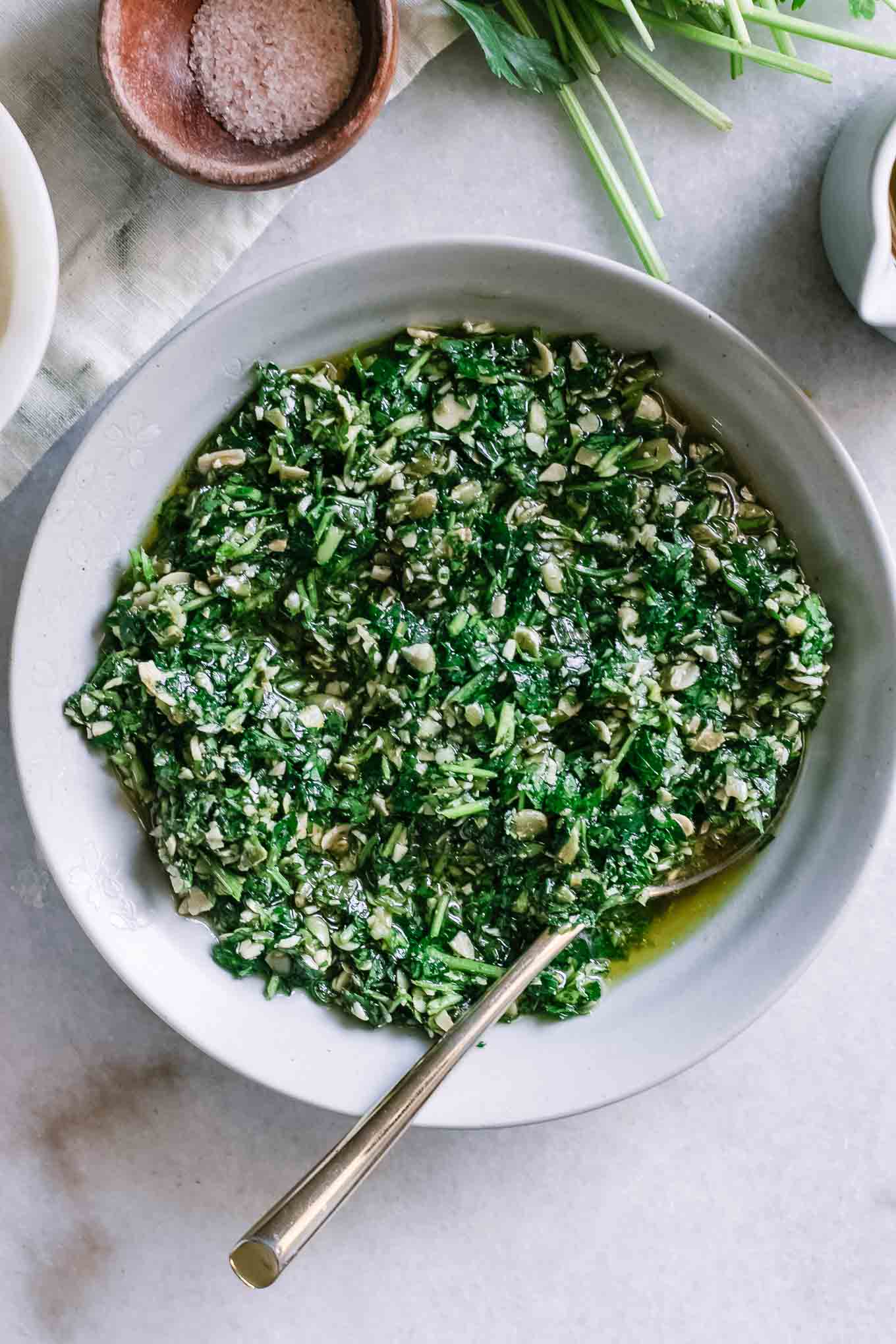 pesto sauce in a bowl with a gold spoon