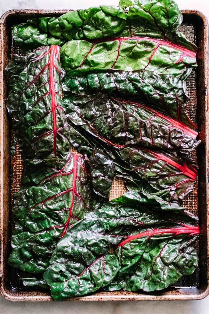 chard leaves on a sheet pan before baking