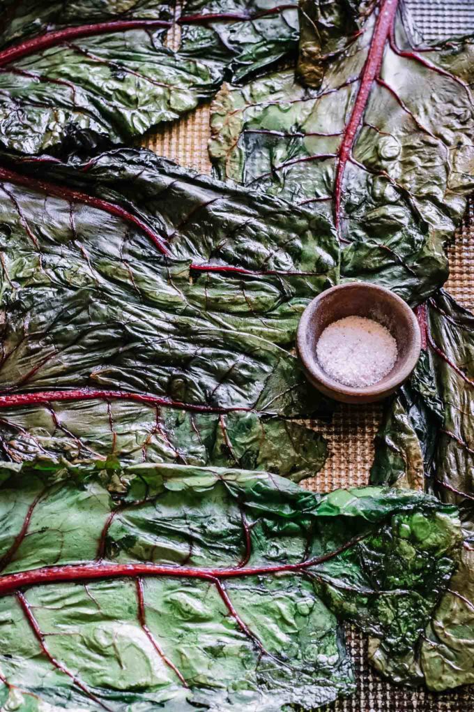 baked chard leaves on a sheet pan with salt