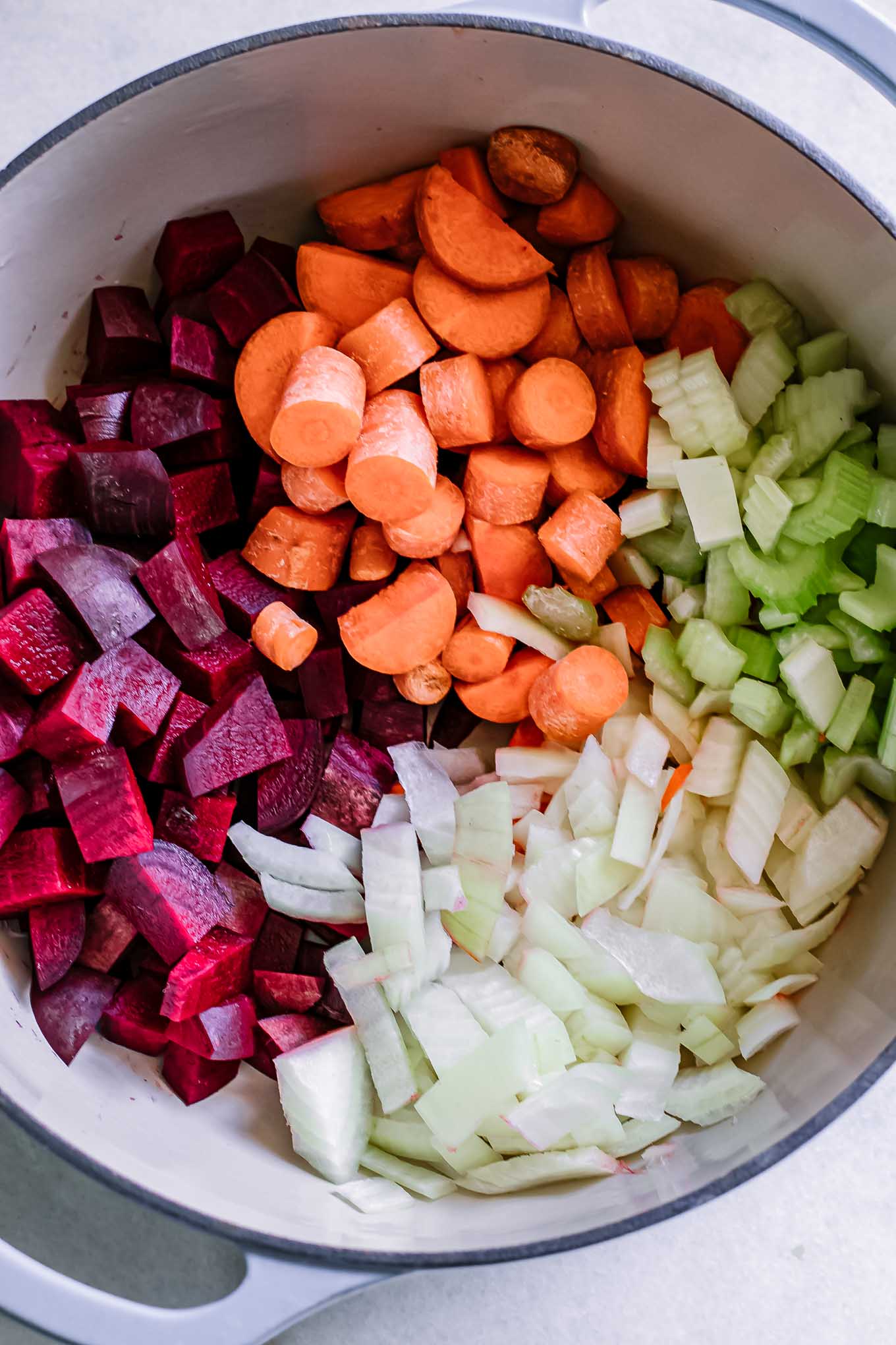 diced beets, carrots, celery, and onions in a soup pot