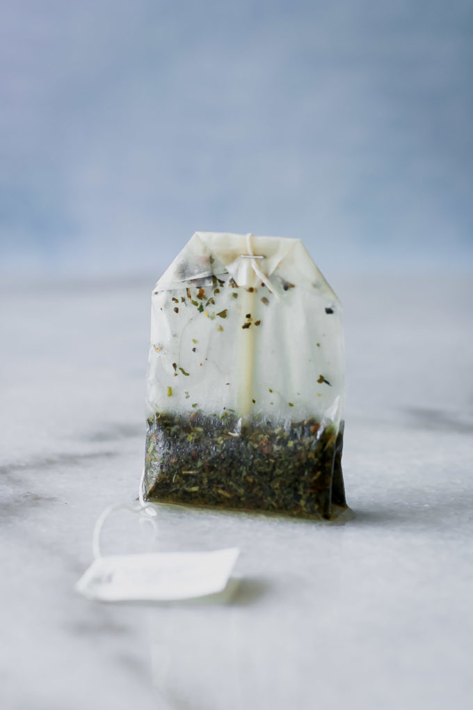 a used tea bag sealed with a metal clip on a marble table