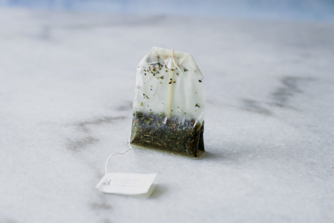 a used tea bag on a white marble countertop