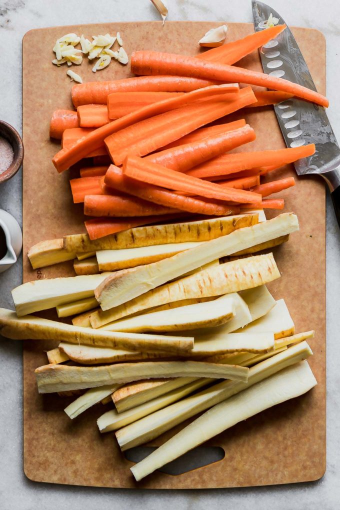 sliced carrots and parsnips on a wooden cutting board