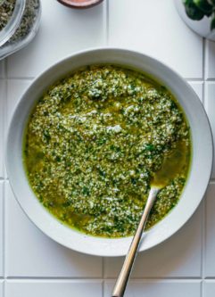 hemp seed pesto in a white bowl with a gold spoon