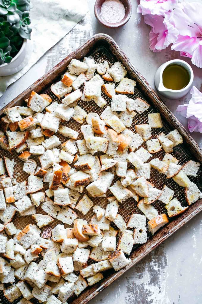 cut rye bread on a baking sheet with bowls of salt and oil