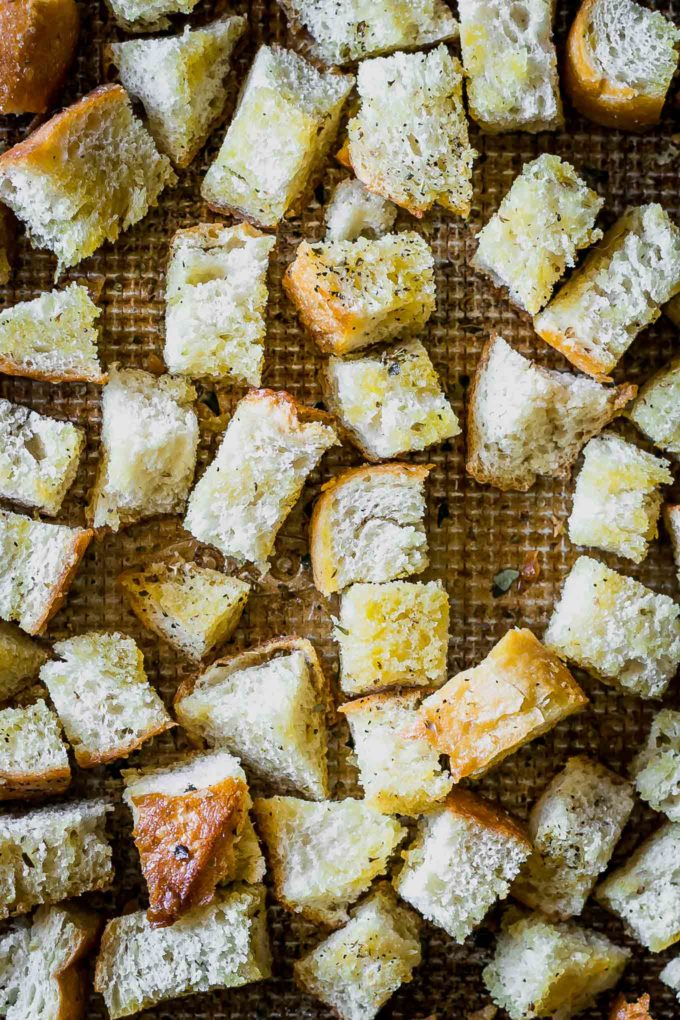 close up of seasoned sourdough croutons on a baking pan