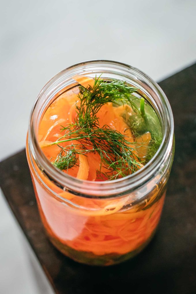 close up of opened jar of pickled carrot ribbons