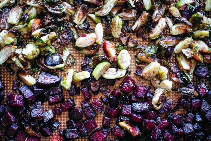 close up of roasted beets and brussels sprouts on a roasting pan after baking