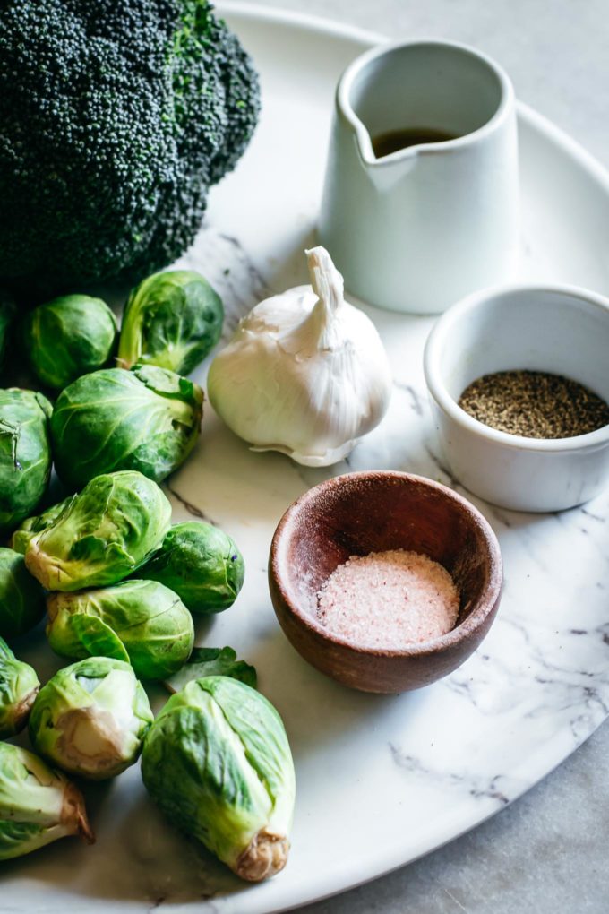 brussels sprouts, broccoli, garlic, and bowls of salt, pepper, and oil