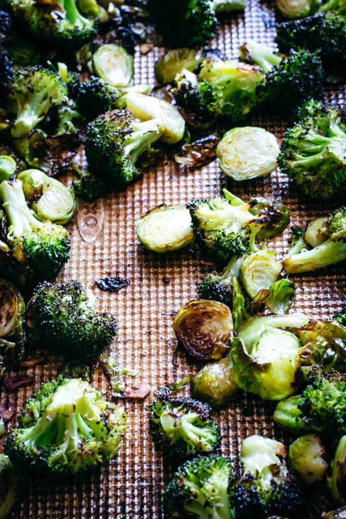 cooked broccoli and brussels sprouts on a baking sheet