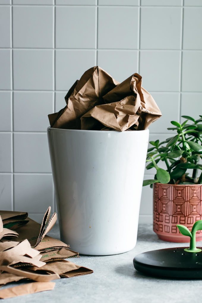 white compost bin containing an old paper bag